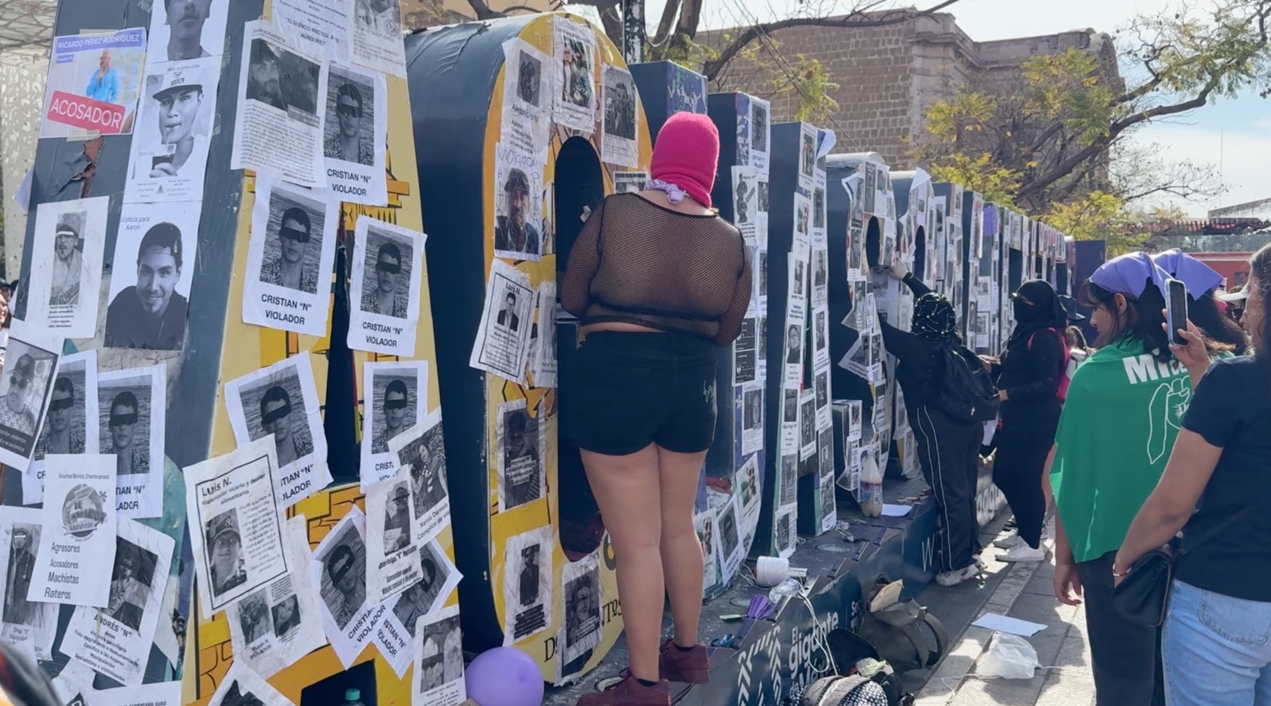 Manifestantes cubrieron letras de la ciudad con fotografías de presuntos violentadores y deudores.
