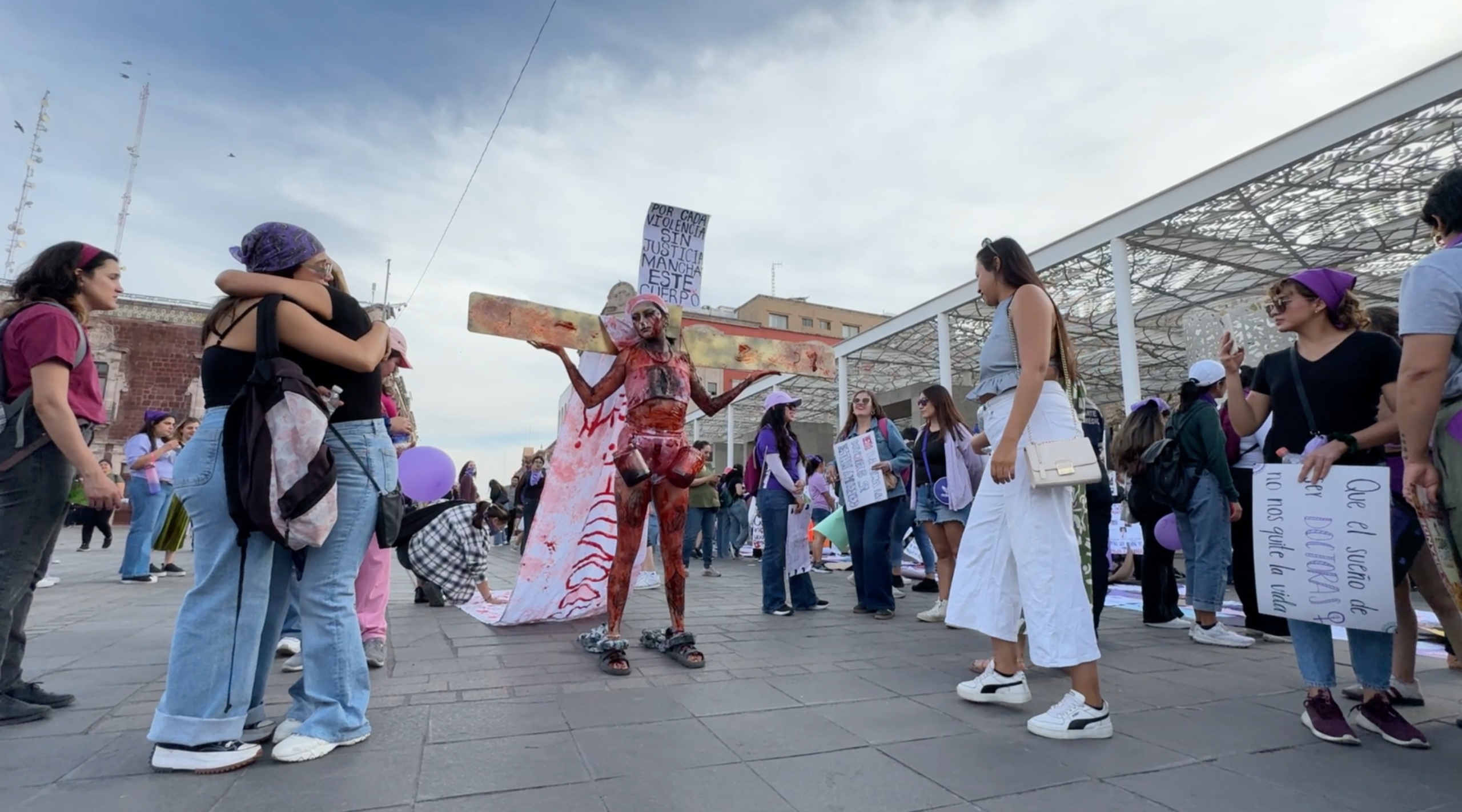 Manifestante hizo performance cargando una cruz.