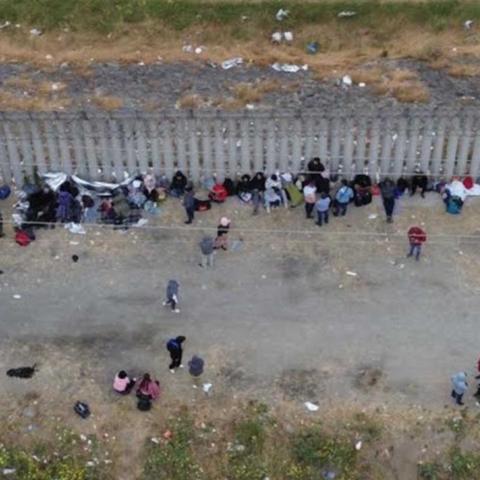 Migrantes duermen junto al muro fronterizo en Tijuana en busca de asilo humanitario