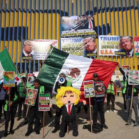 Migrantes protestan frente al muro fronterizo contra Donald Trump