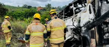 Bomberos del Ejército inspecionan el autobús calcinado tras apagar las llamas.