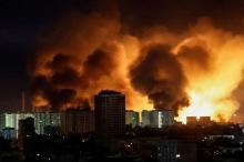 Bombardeo a Ucrania muestra una nube de humo y fuego entre edificios durante la noche